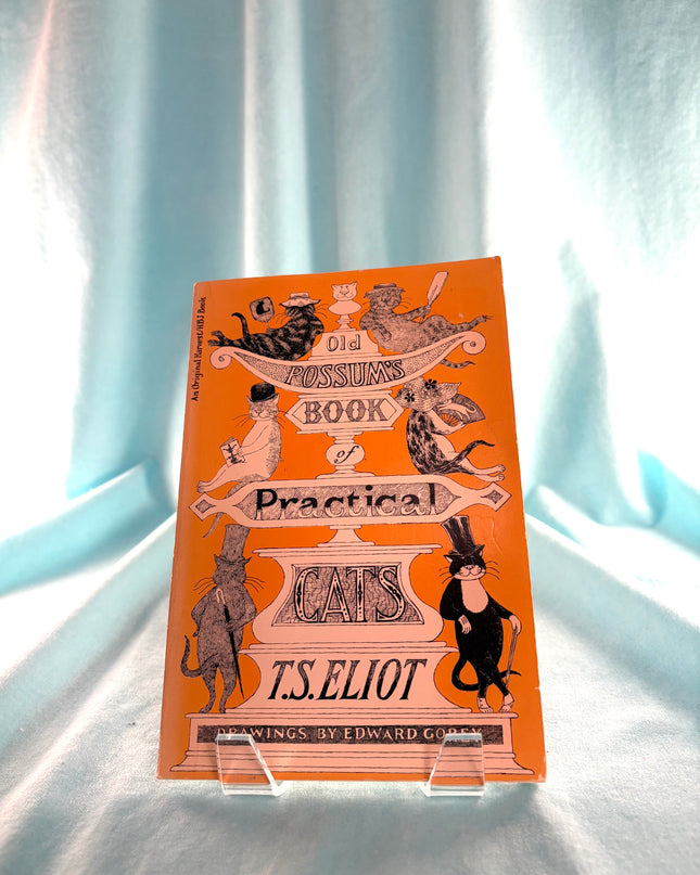 Book cover of 'The Book of Practical Cats' by T.S. Eliot on a light blue curtain background