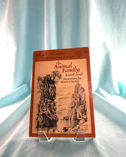 Book titled 'The Animal Family' on a stand with a light blue curtain background