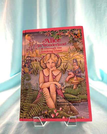 Book cover of 'Alice in Wonderland & Through the Looking Glass' on a stand with a light blue background