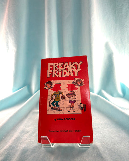 Red book titled 'Freaky Friday' on a stand with a light blue curtain background