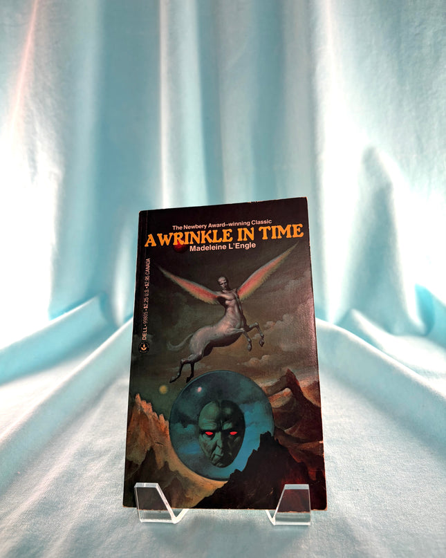 Book titled 'A Wrinkle in Time' on a stand against a light curtain background