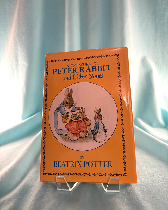 Book titled 'A Treasury of Peter Rabbit and Other Stories' by Beatrix Potter on a light blue fabric background