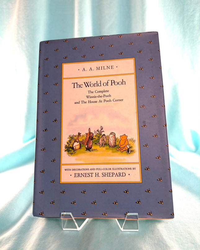 Book titled 'The World of Pooh' by A.A. Milne on a light blue background