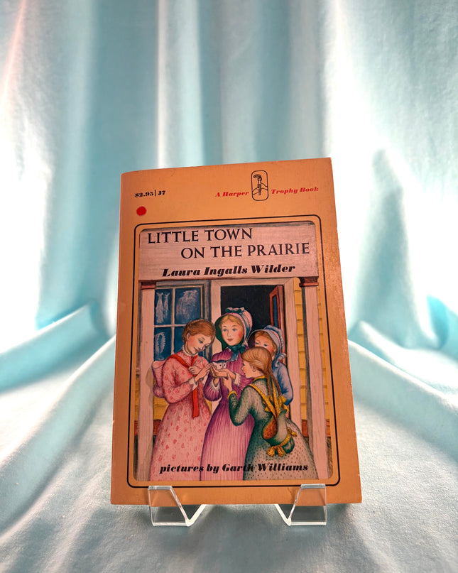 Book titled 'Little Town on the Prairie' by Laura Ingalls Wilder on a light blue fabric background