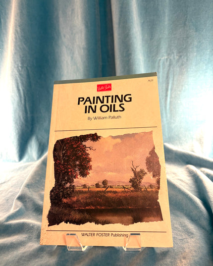 Book titled 'Painting in Oils' by William Faludi on a blue fabric background
