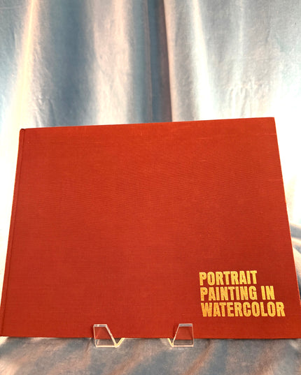 Red book titled 'Portrait Painting in Watercolor' on a silver background