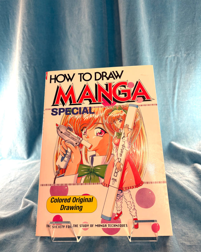 Book titled 'How to Draw Manga Special' on a blue fabric background