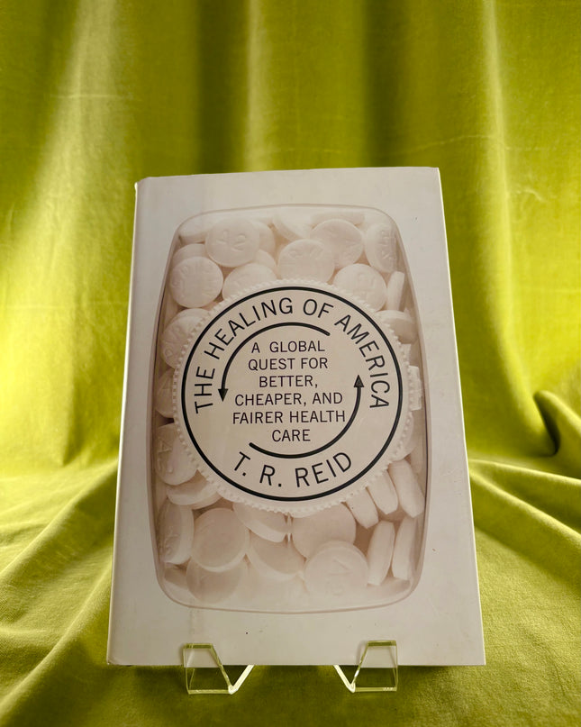 Book titled 'The Healing of America' by T.R. Reid on a green fabric background