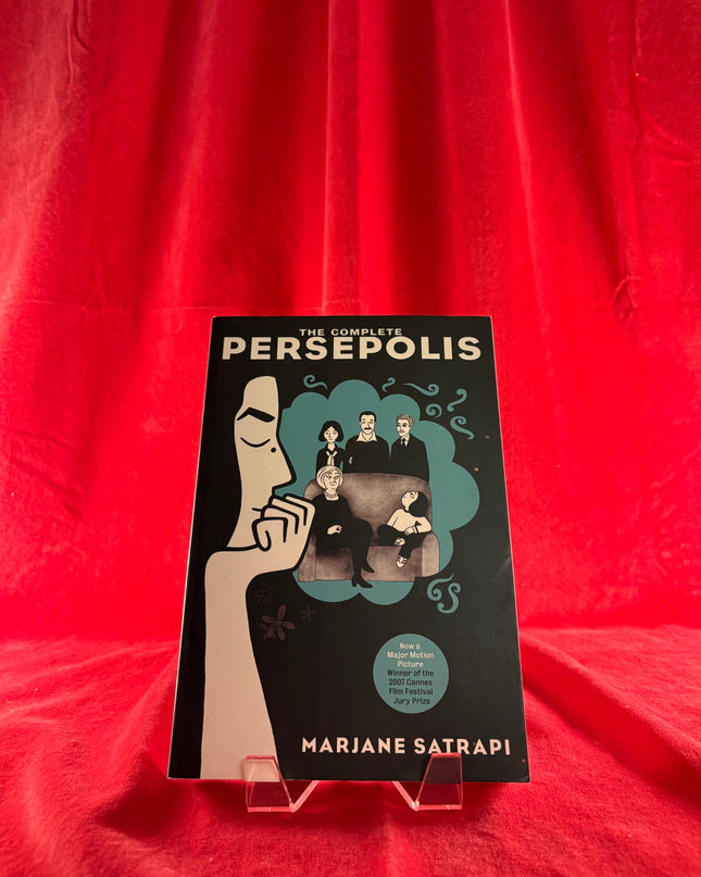 Book titled 'The Complete Persepolis' by Marjane Satrapi on a red background